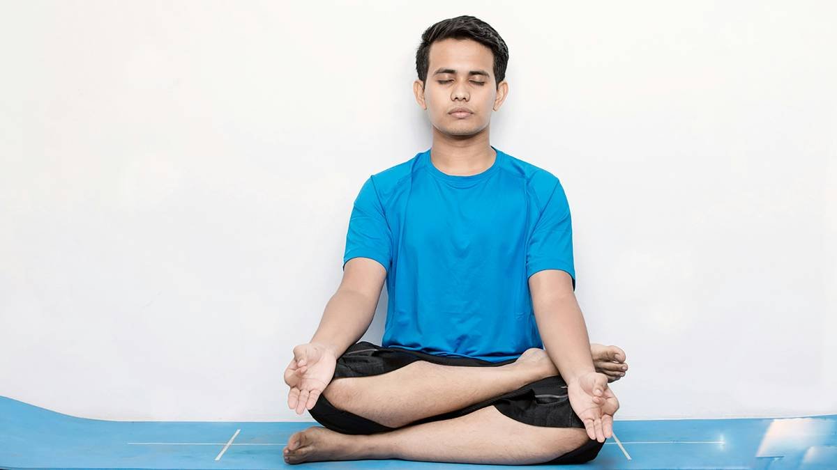 A person meditating while using headphones, representing focus training hypnosis